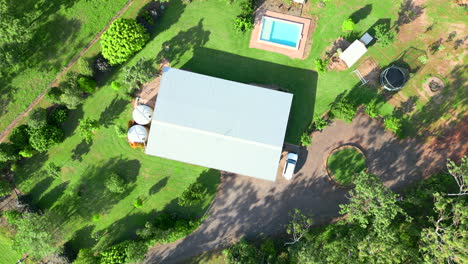 Aerial-drone-of-Rural-Acreage-Block-with-Home-on-Countryside-Property-Complete-with-Pool-and-Roundabout,-Top-Down-Descend-Rotate