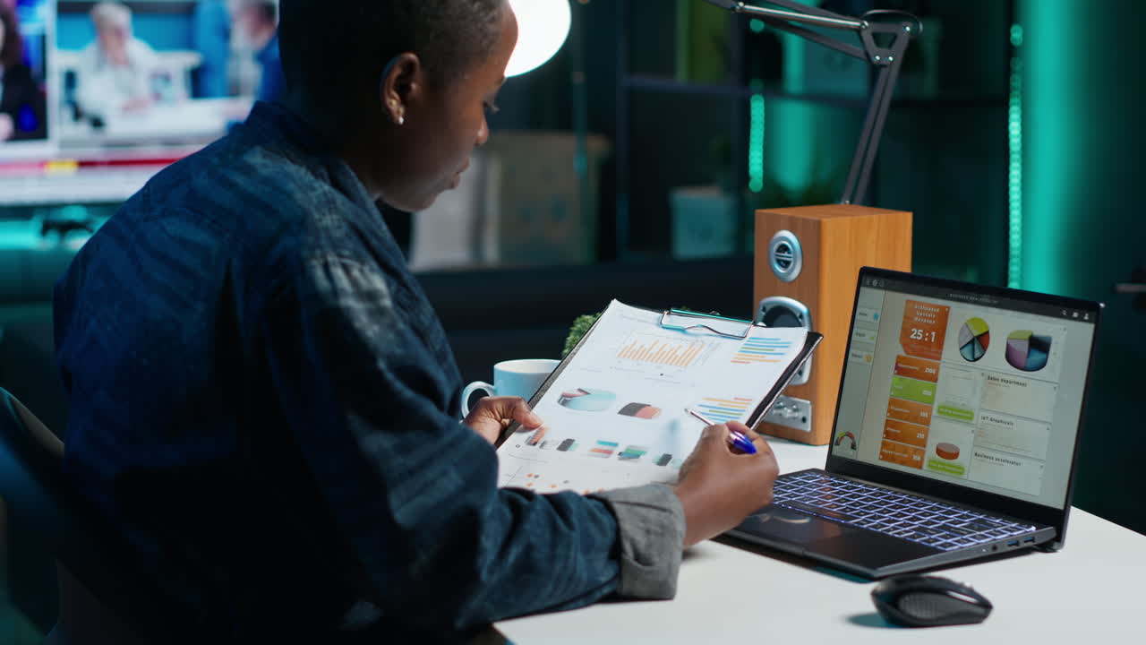 Woman working late at night on laptop and reports