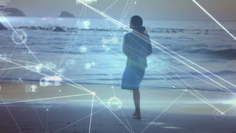 animación de procesamiento de datos y redes de conexiones sobre mujer caucásica caminando por la playa