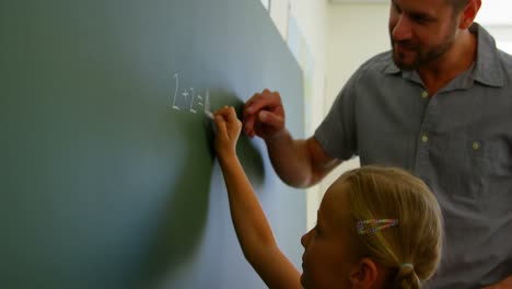 estudiante que resuelve una ecuación matemática en la pizarra en el aula 4k