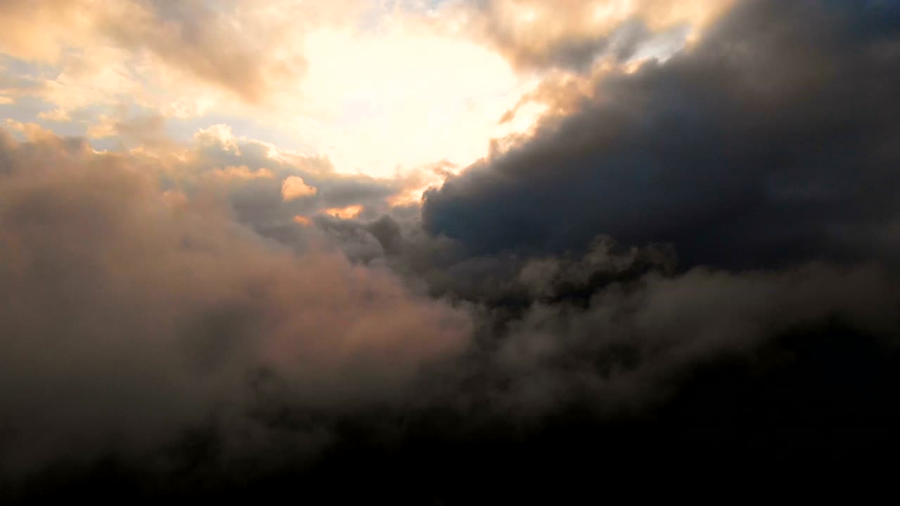 la cámara se extiende a través de las nubes de lluvia de la noche al atardecer por encima de los niveles de nubes. fabuloso vuelo en las nubes. vista aérea