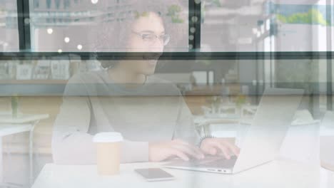 animación de una mujer sonriente usando una computadora portátil en una cafetería sobre colegas caminando en un edificio moderno