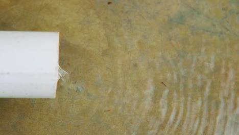 water continuously pouring out of a pvc pipe - close up