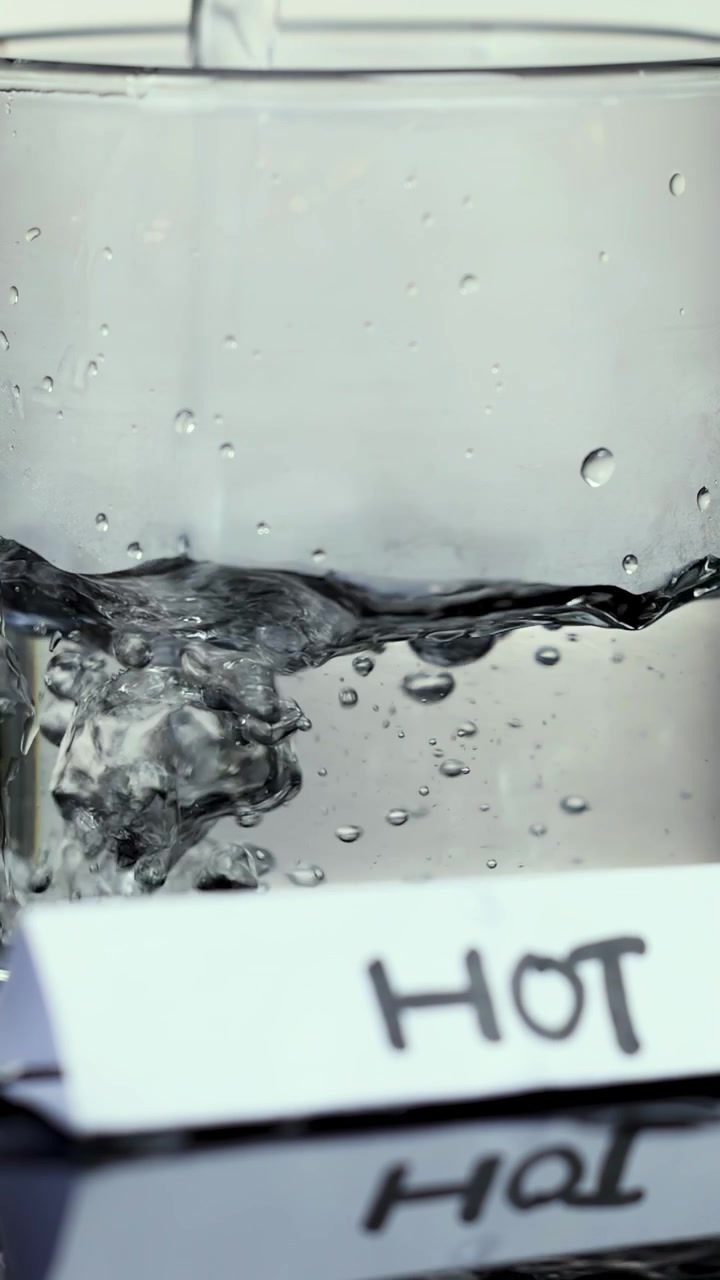 Acqua limpida versata in un bicchiere con un'etichetta 'Hot'