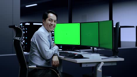hombre de negocios en la sala de servidores con múltiples monitores