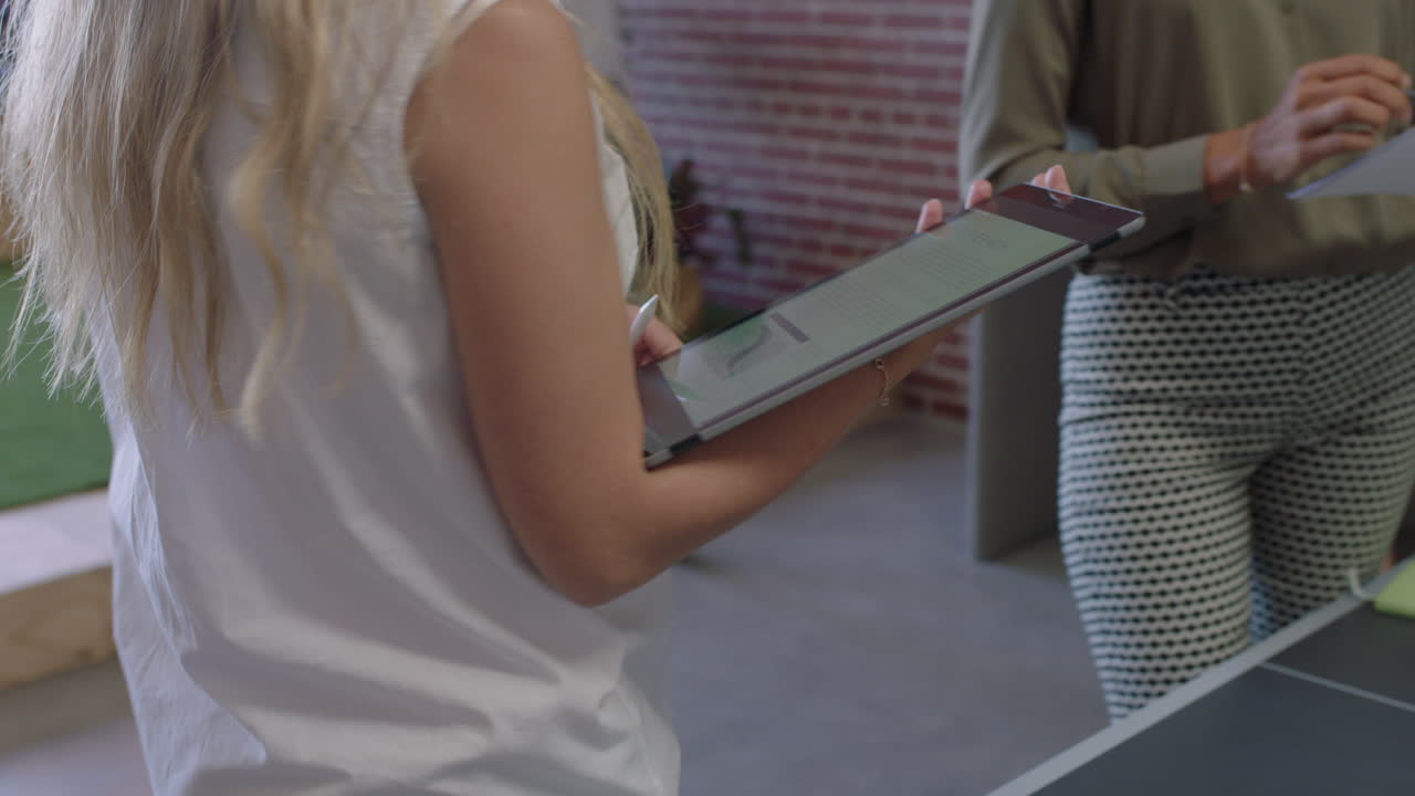 mujeres de negocios multiétnicas que se reúnen para intercambiar ideas utilizando datos gráficos en tabletas jefe embarazada mujer que comparte estrategia en el lugar de trabajo de la oficina moderna