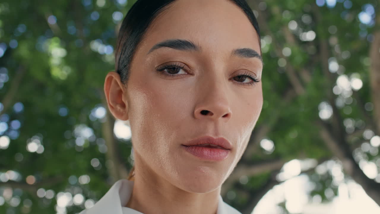 retrato de una mujer tranquila y elegante de pie frente a la vegetación de verano.