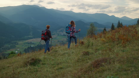 walking couple hiking mountains. two travelers going trekking poles in nature.