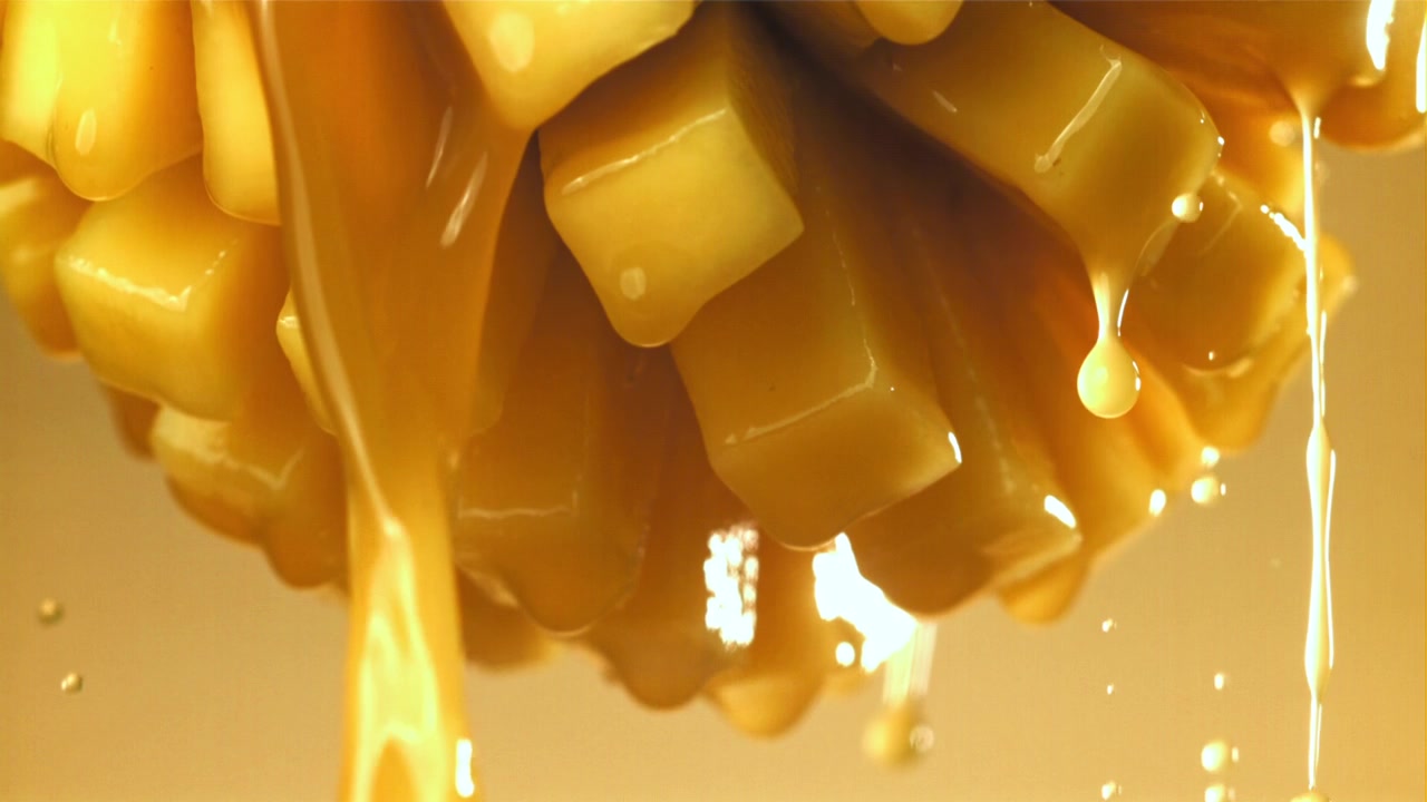 Delizioso sciroppo al caramello che cola su pezzi freschi di mango.