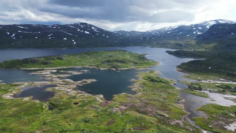 Dramatic-Nature-Landscape-in-Norway---Stavatn-Lake-and-Snow-Covered-Mountains-Peaks---Vestland,-Vestfold-og-Telemark---Aerial