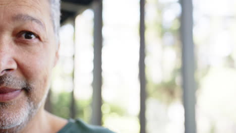 Portrait-of-happy-biracial-senior-man-in-sunny-outdoors,-copy-space