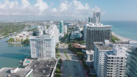 aerial panoramic view of modern urban neighbourhood on seaside with tall buildings. tilt down on multilane road and intersection. miami, usa