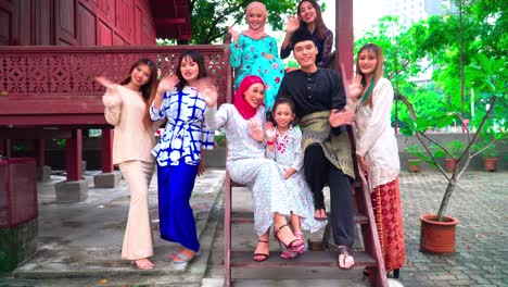 a group of malay people at the wooden house celebrating hari raya festive