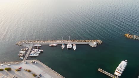 beautiful aerial footage of boats and sailing yachts docked in the picturesque naoussa marina of paros, greece