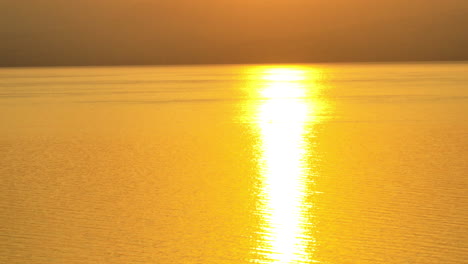 three friends paddleboard on the lake during sunrise