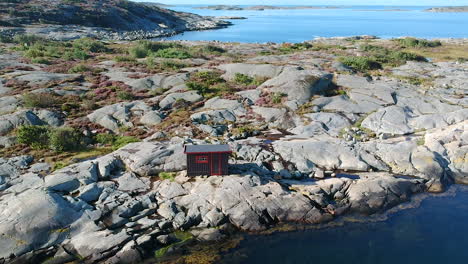 aerial drone shot of a cabin at a rocky ocean coastline on the west coast of sweden in halland, outside of gothenburg