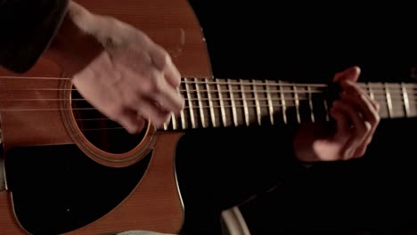 man plays the guitar and sings songs in a tent with light bulbs