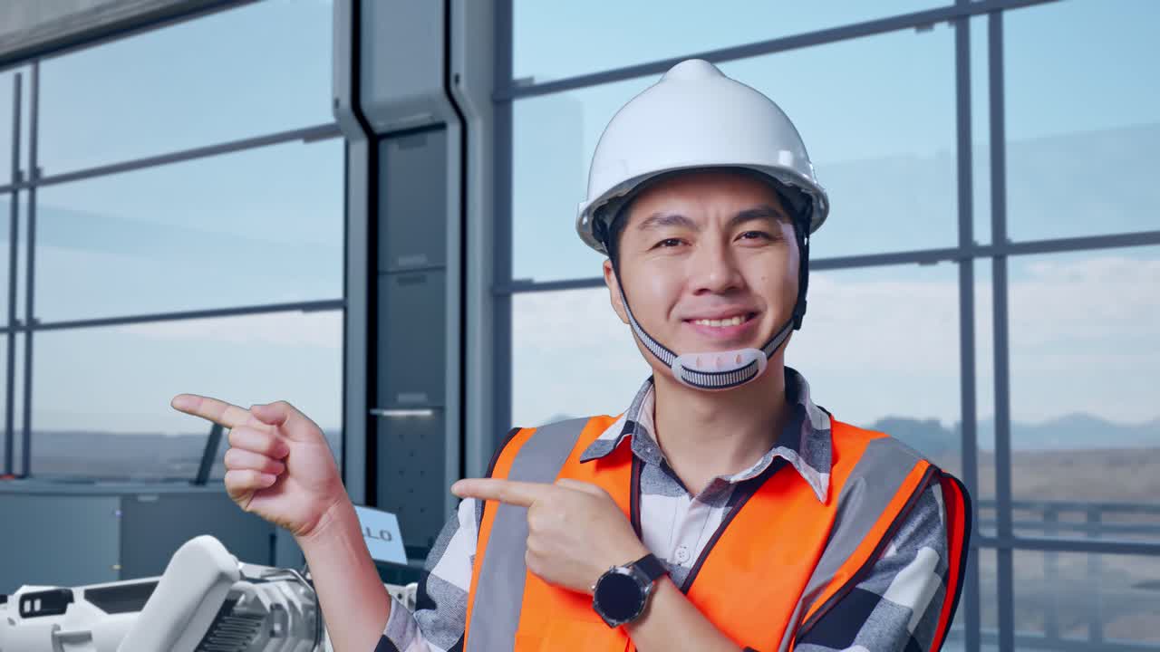 웃는 엔지니어가 현대 직장에서의 기술을 가리키고 있습니다.