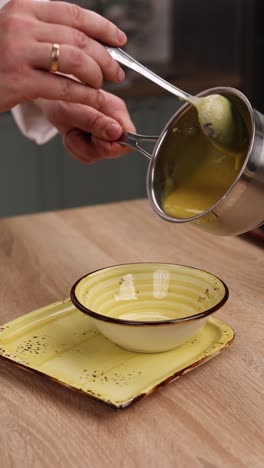 chef pouring soup into a bowl