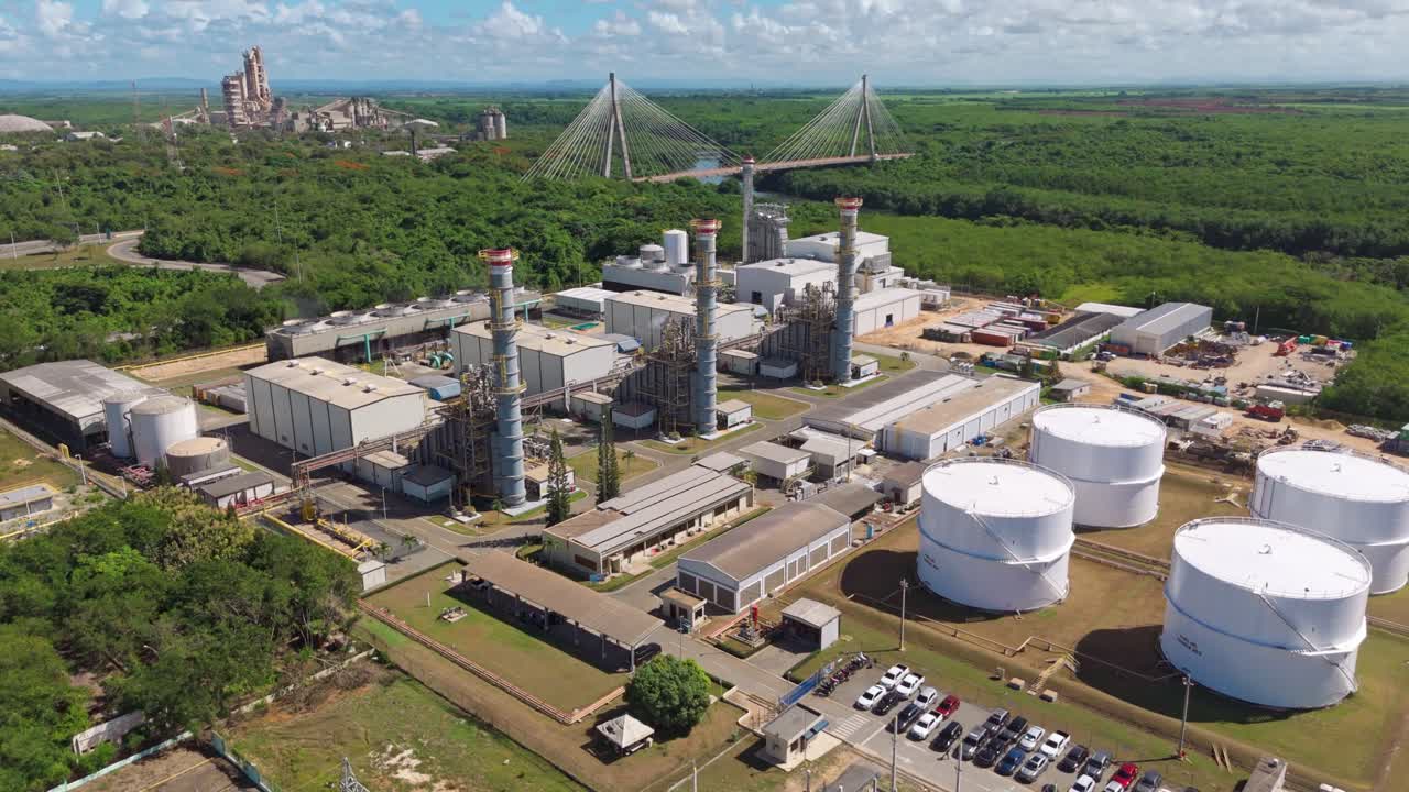 Drone view of generation facility, fuel storage tanks, substation, and smokestacks in San Pedro de Macoris, Dominican Republic