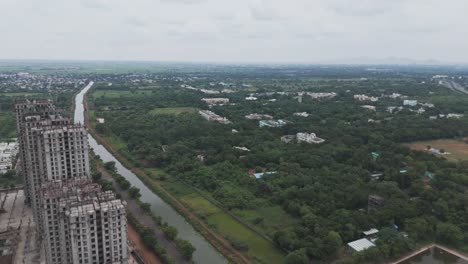 aerial view of urban development and construction near a canal in india