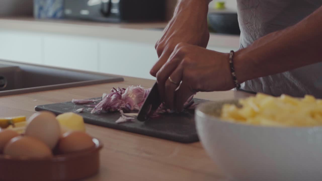 Professional home chef slicing red onions on chopping board, slow motion