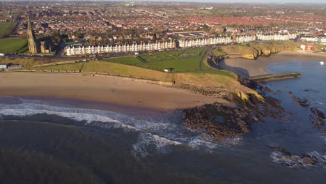 drone perspective of tynemouth coastline with longsands beach and cullercoats beach at sunrise