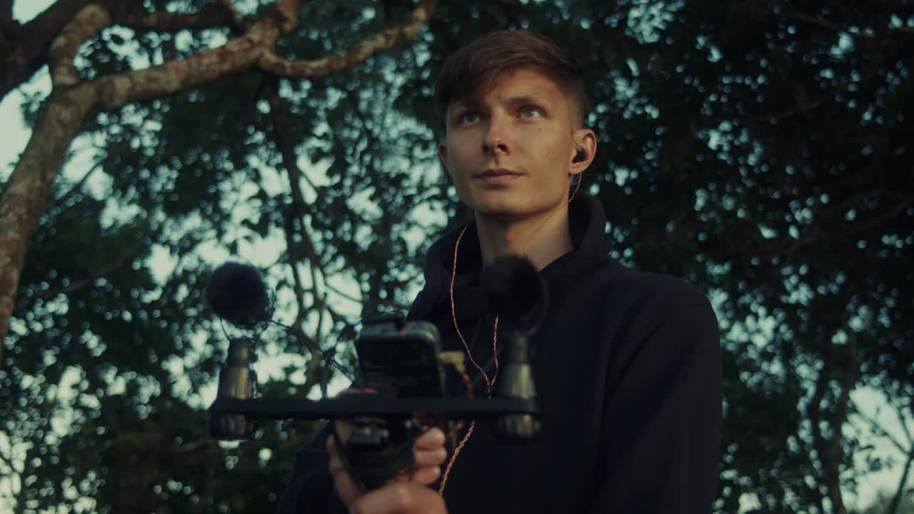 Young Man Recording Audio Outdoors