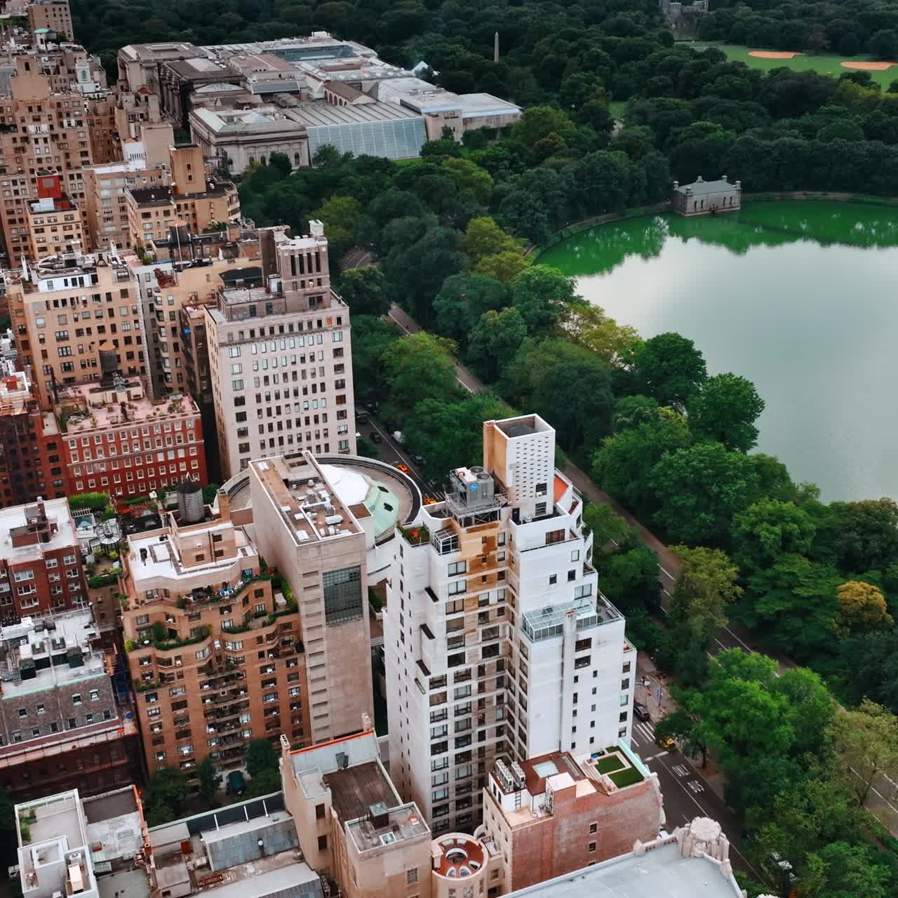 Densely built neighborhood near the Central Park in New York. Urban landscape contrasting with greenery of nature. Top view