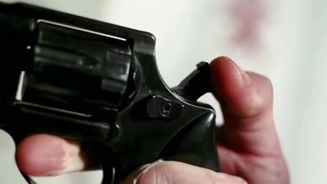 close up of a person's hand pulling the hammer of a revolver pistol, boke shot of a firearm