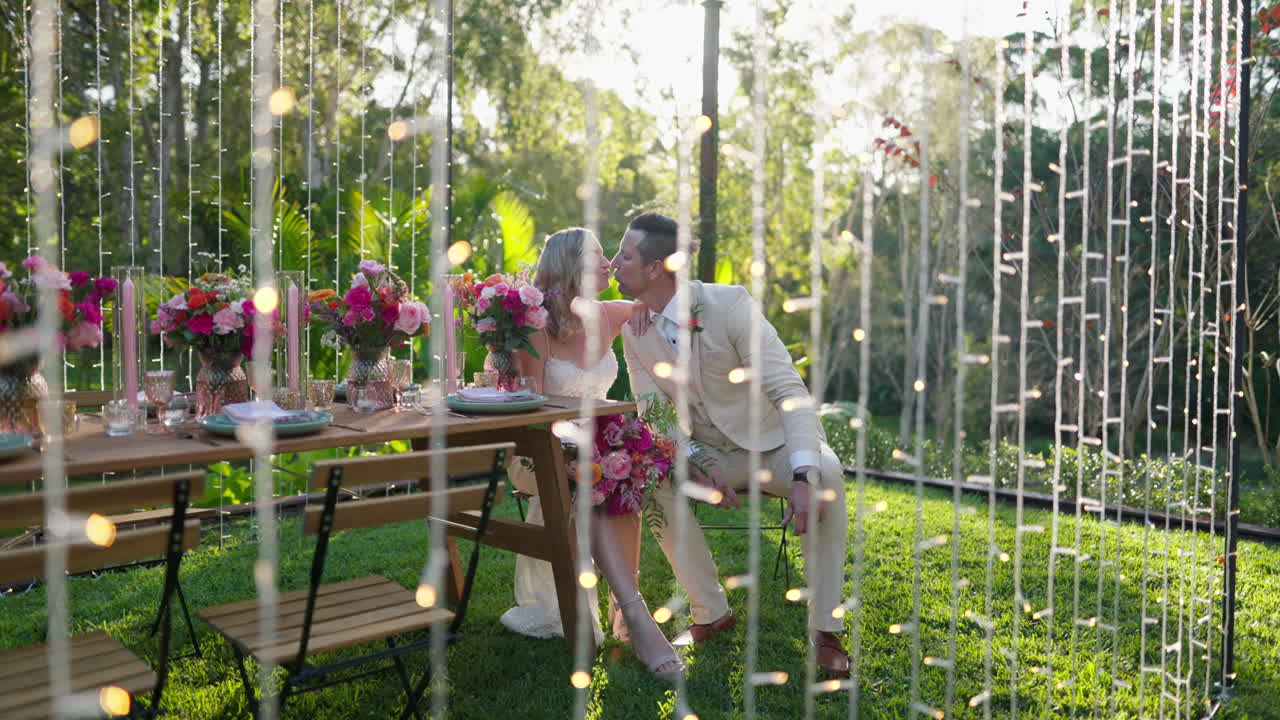 Beautiful Romantic Bride And Groom Kissing At Wedding Reception Table Setup With Waterfall Lights, 4K Slow Motion