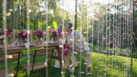 beautiful romantic bride and groom kissing at wedding reception table setup with waterfall lights, 4k slow motion