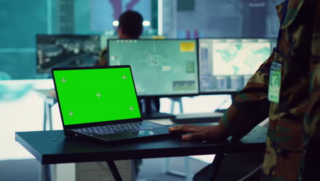 el comandante examina una pantalla verde en la computadora portátil en el centro de mando militar