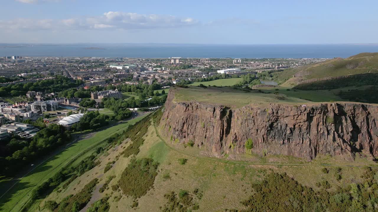 Awesome aerial orbit around Salisbury Crags steep cliffs, Edinburgh, Scotland, UK