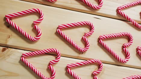 Video-of-red-and-white-candy-canes-on-wooden-background