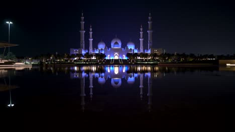 famous grand mosque in abu dhabi, united arab emirates at night with a reflection in the pool