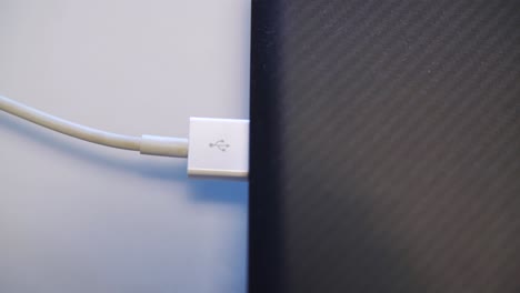 hand connecting usb cable to a laptop