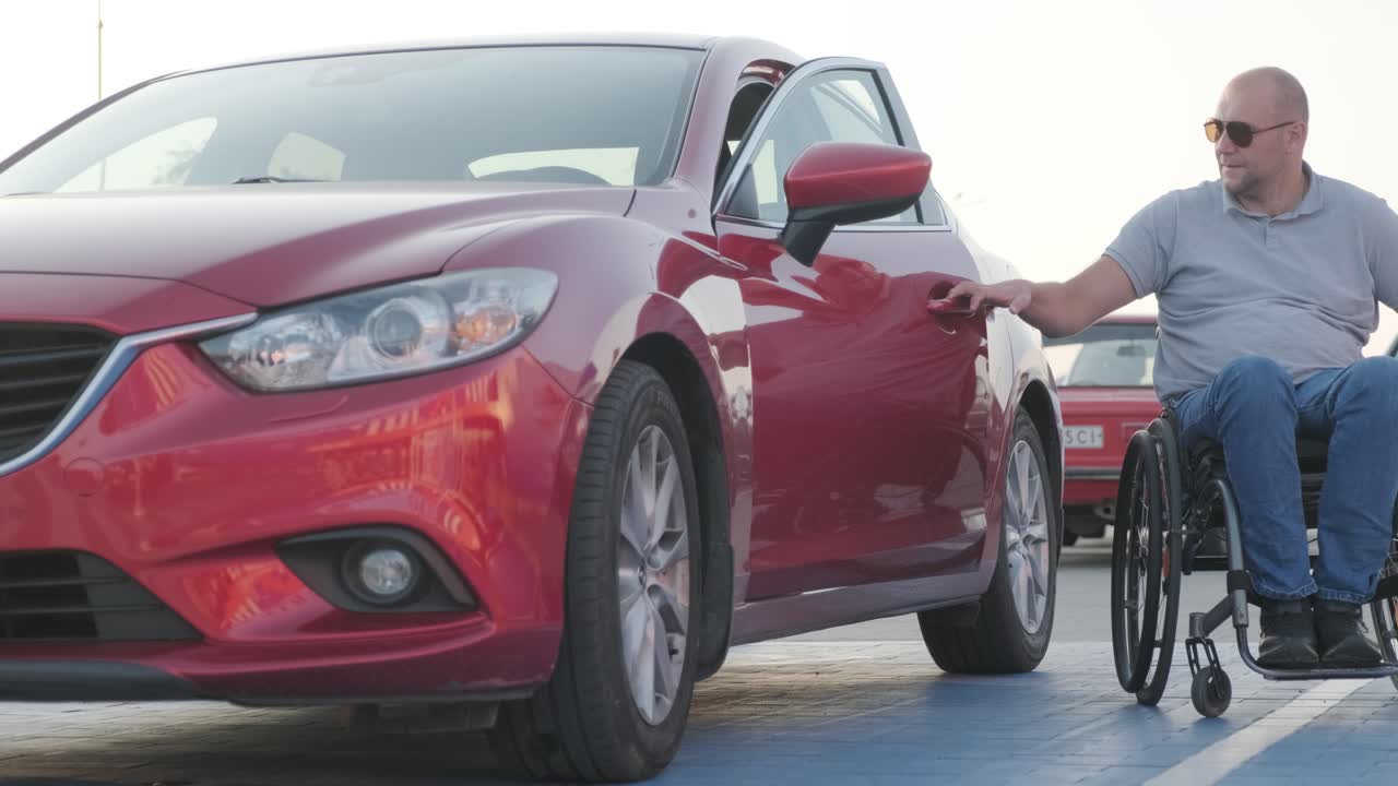 joven conductor discapacitado entrando en un coche rojo de silla de ruedas