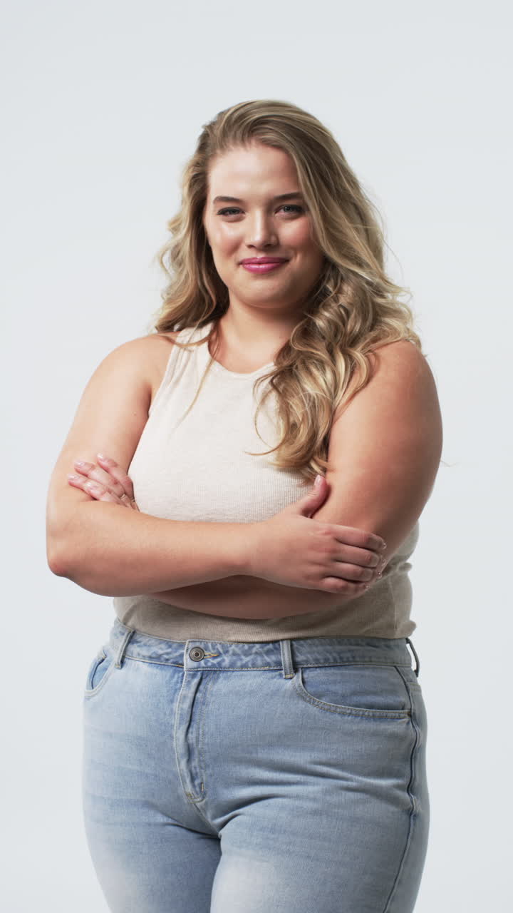 Video verticale: Donna taglia forte sorridente con le braccia incrociate che abbraccia la body positivity.