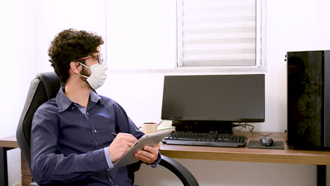 trabajo higiénico en casa escribiendo en una tableta táctil mirando a la izquierda