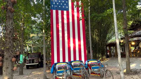 pedicabs parked beside a large american flag