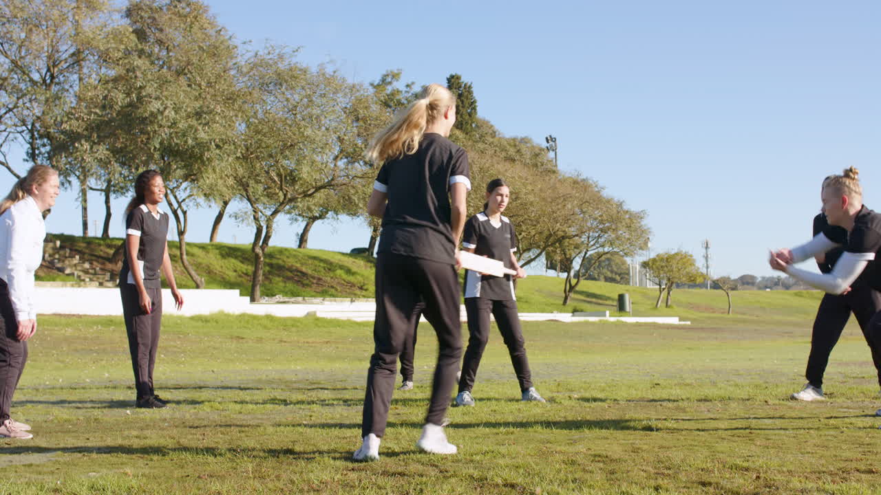 Practicing cricket outdoors, women playing together on sunny day
