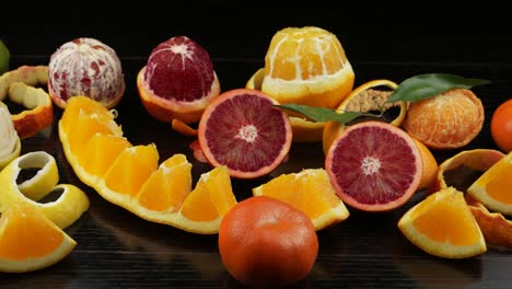 frutas cítricas, cortadas en rodajas decorativas, en una mesa de madera negra.