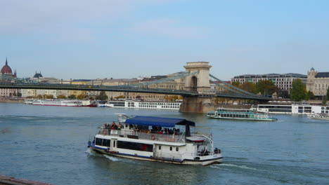 tourist ships sail in danube river near bridge in budapest hungary