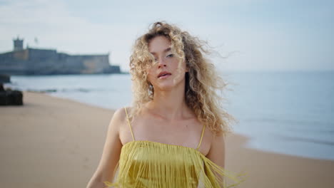 carefree tourist walking beach looking camera with gentle smile close up.