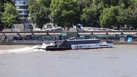 uber boat moving along the thames river