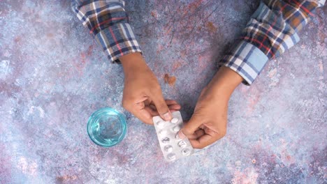 person taking pills with water