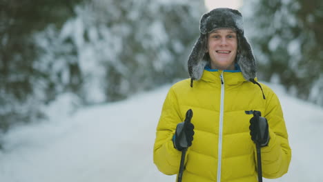 hombre sonriente con esquís y su esposa mirando algo curioso durante el viaje en el bosque invernal