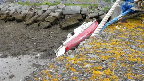 Zerschmettertes-Beschädigtes-Kleines-Altes-Kaputtes-Bootswrack,-Das-Auf-Dem-Fischerhafen-Gestrandet-Ist,-Schaukelt-Dolly-Rechts