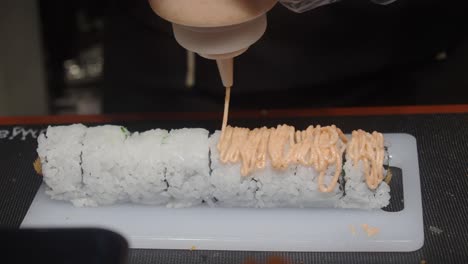 preparing sushi rolls with sauce
